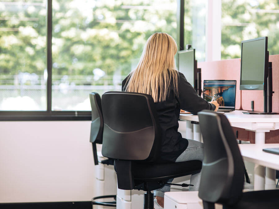 woman working at a standing desk on a buro roma drafting chair woman working at a standing desk on a buro roma drafting chair
