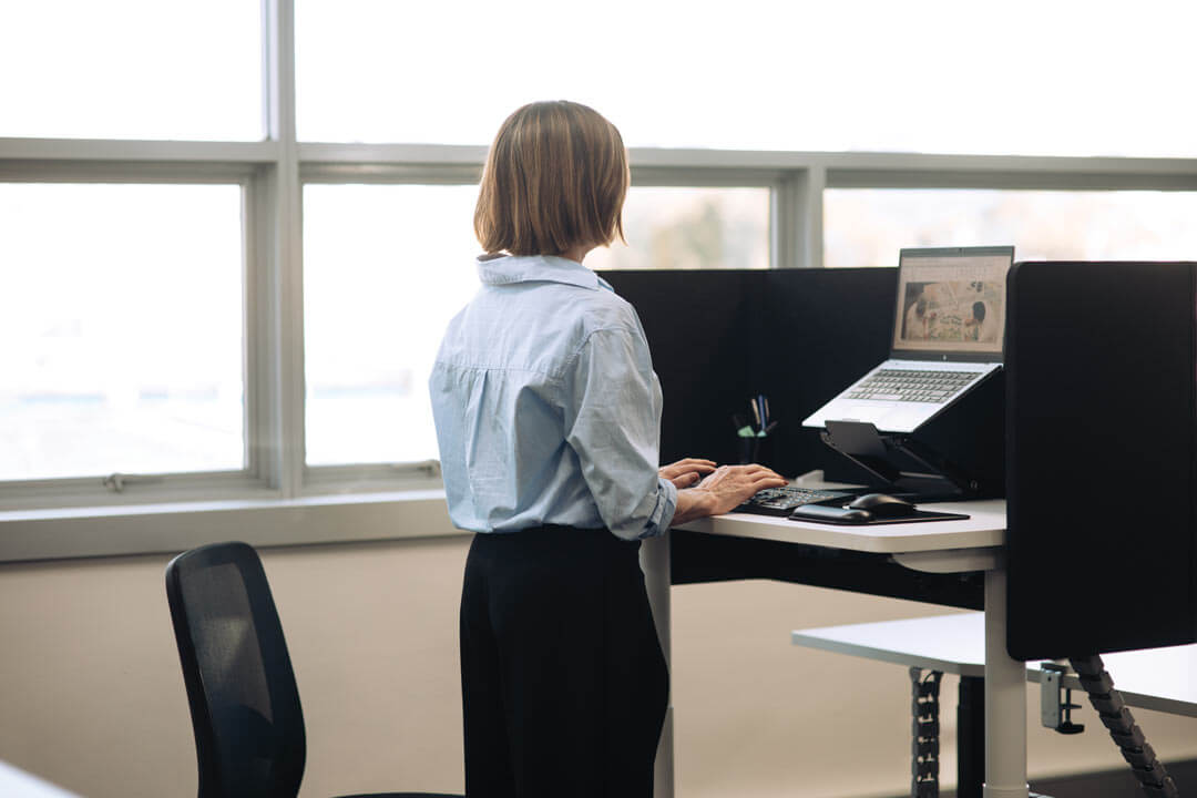 buro syntra 1200 x 600 woman standing at buro syntra desk